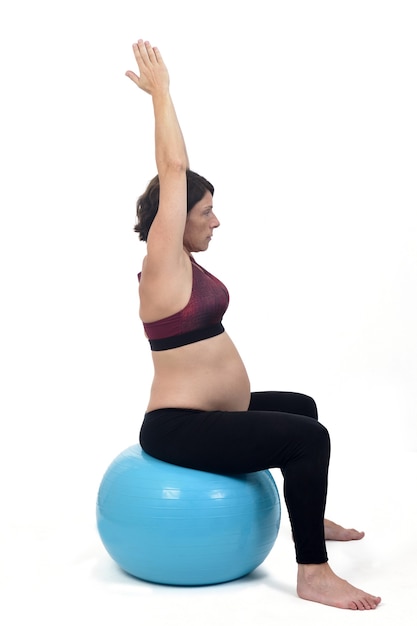 Femme enceinte exerçant avec un ballon sur fond blanc