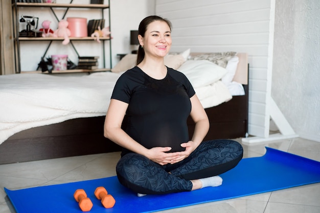 Femme enceinte exerçant le yoga à la maison. Yoga de grossesse et fitness.