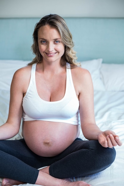 Femme enceinte, faire du yoga sur son lit