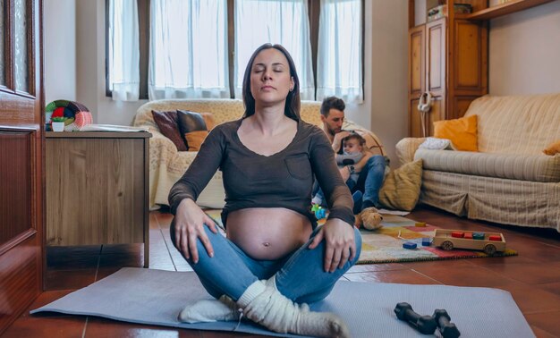 Photo femme enceinte faisant de l'exercice dans le salon de sa maison