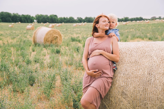 Photo femme enceinte et fils dans la nature mère attendant un deuxième bébé