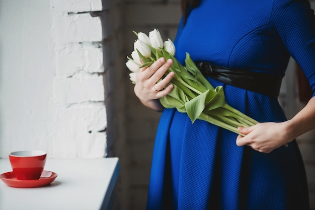 Une femme enceinte avec des fleurs blanches