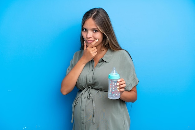 Femme enceinte sur fond bleu pensant