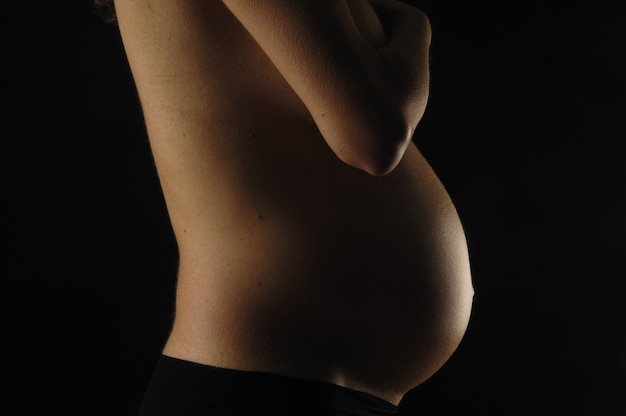 Femme enceinte avec un fond noir