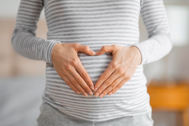 Une femme enceinte formant une forme de cœur sur le ventre