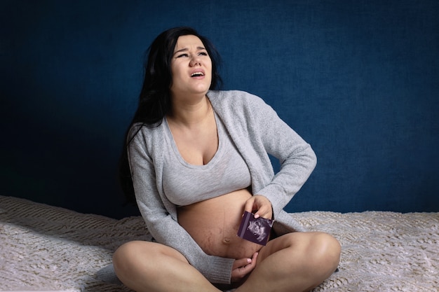 Femme enceinte grimace de douleur dans la chambre