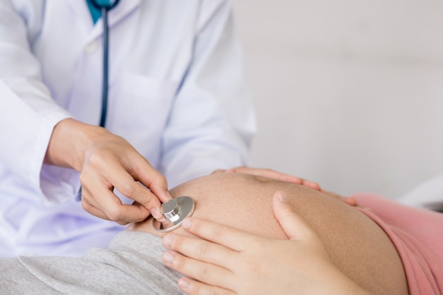 Une femme enceinte heureuse rend visite à un médecin gynécologue à l'hôpital