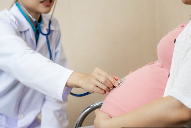 Une femme enceinte heureuse rend visite à un médecin gynécologue à l'hôpital
