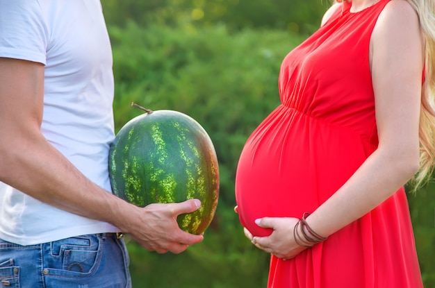 Une femme enceinte et un homme tiennent une pastèque