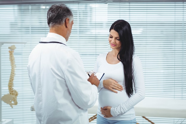 Femme enceinte en interaction avec un médecin en clinique