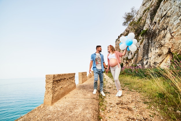 Femme enceinte jeune beauté saine avec son mari et ballons en plein air