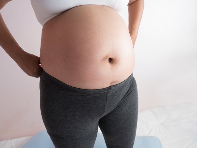 Photo femme enceinte joue avec son bébé dans le ventre.