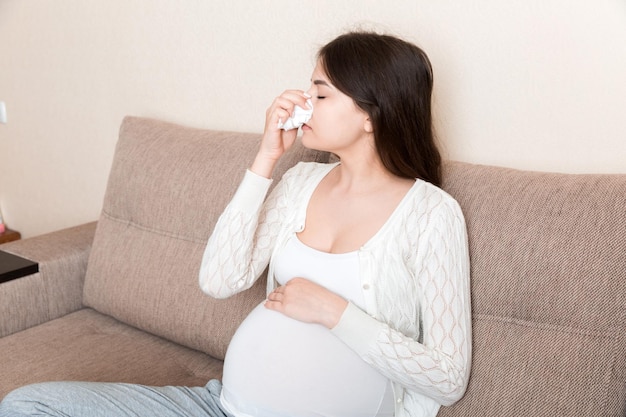 Femme enceinte malade se moucher dans les tissus à la maison Concept de soins de santé millénaire sain