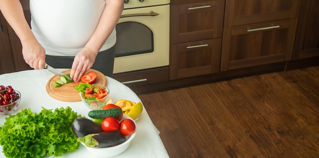 Une femme enceinte mange des légumes et des fruits