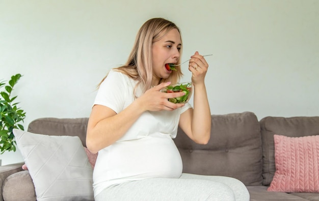 Une femme enceinte mange une salade avec des légumes Mise au point sélective