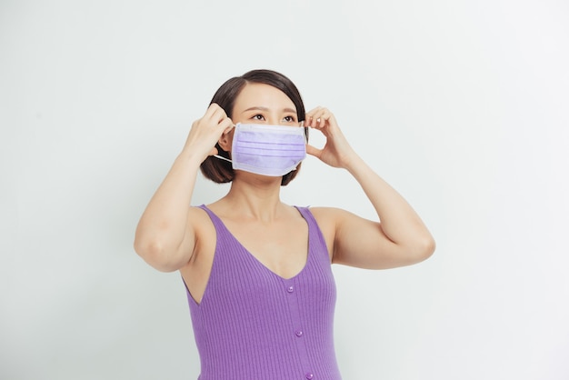 Femme enceinte avec masque médical. Inquiétudes au sujet de l'accouchement pendant la pandémie.