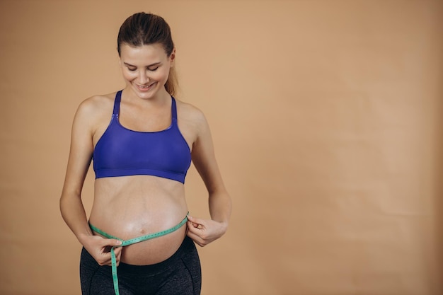 Femme enceinte mesurant le ventre avec un ruban à mesurer