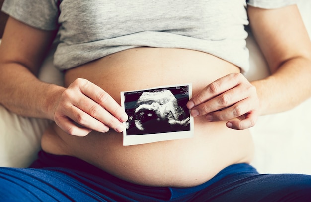 Femme enceinte montrant une photo échographique