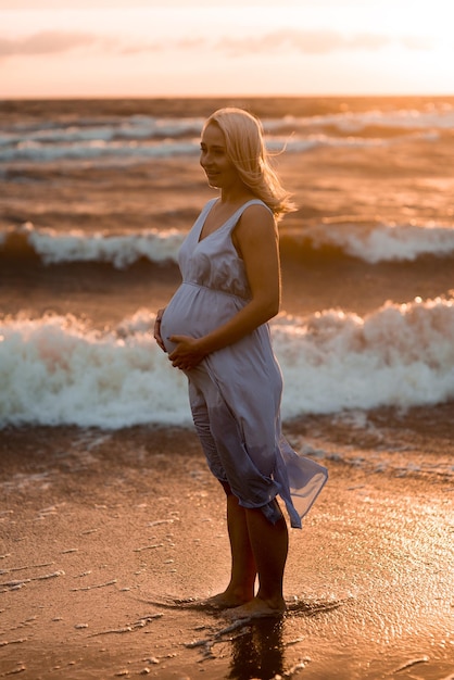 Une femme enceinte sur la plage.