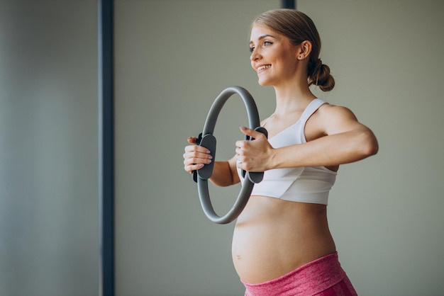 Femme enceinte pratiquant le yoga à la maison