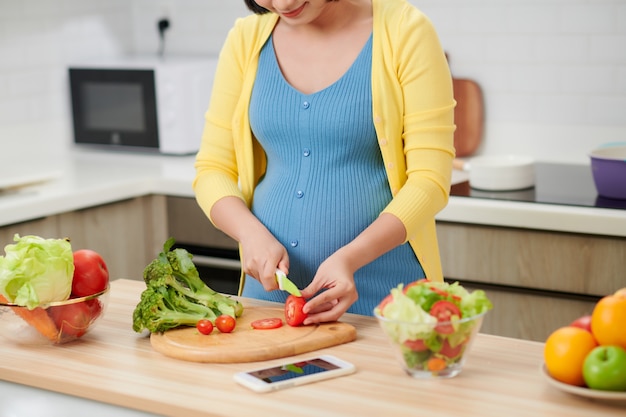 Femme enceinte préparant des aliments sains avec des fruits et légumes. Fermer