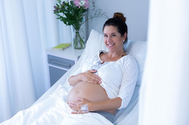 Photo une femme enceinte qui touche son ventre dans la salle d'hôpital.