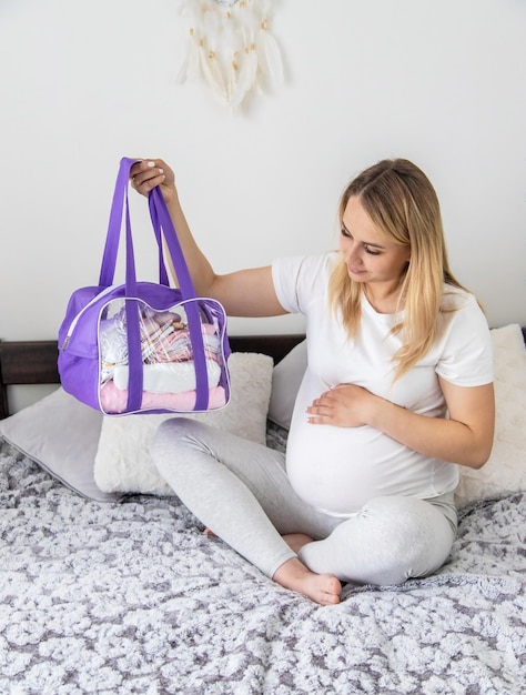 Une femme enceinte ramasse des objets pour bébé Mise au point sélective Accueil