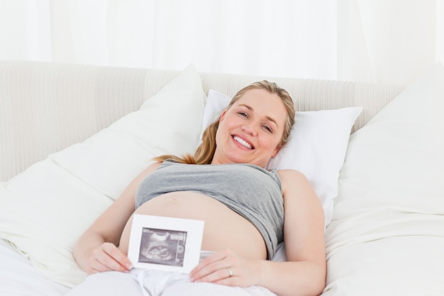 Femme enceinte ravie avec sa radiographie