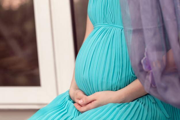 Femme enceinte sur le rebord de la fenêtre