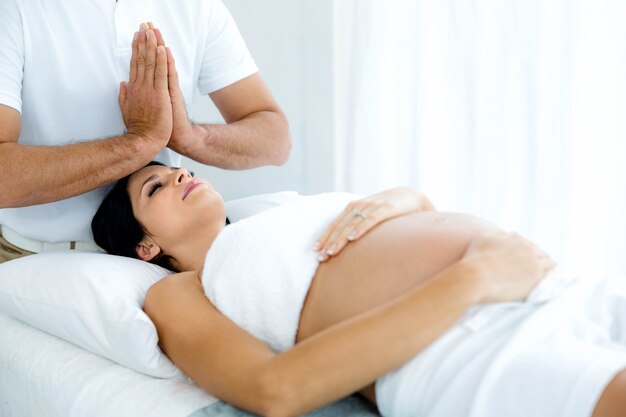 Femme enceinte recevant un traitement de spa d'un masseur à la maison