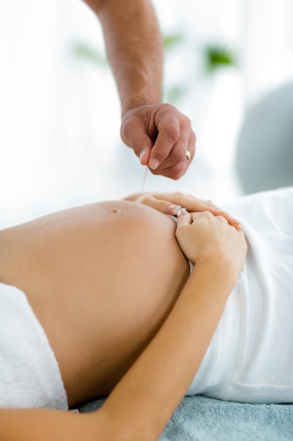 Femme enceinte recevant un traitement de spa d'un masseur à la maison