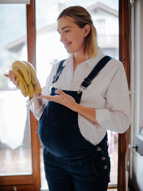 Femme enceinte regardant des bananes