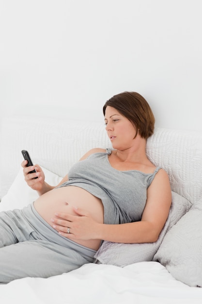 Femme enceinte en regardant son portable