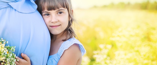 Femme enceinte avec sa fille dans un champ de camomille