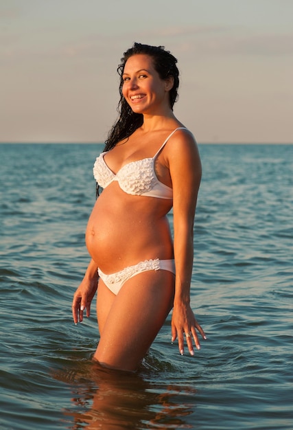 Femme enceinte se baignant dans la mer