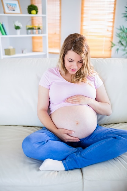 Femme enceinte, séance, sur, divan, toucher, elle, ventre