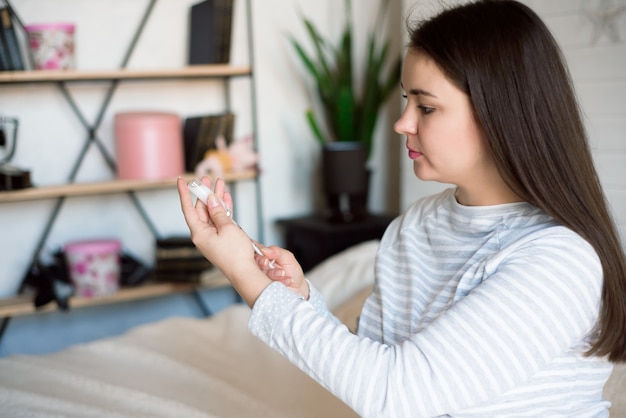 Femme enceinte avec une seringue à insuline à la maison sur le lit. Concept de diabète enceinte.