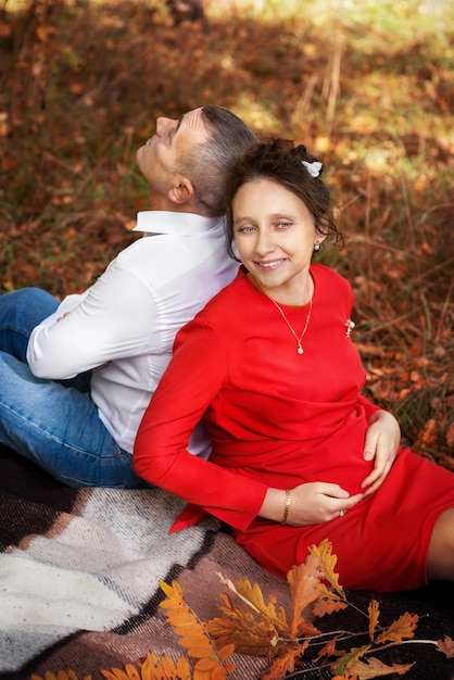 Femme enceinte avec son mari dans le parc en automne