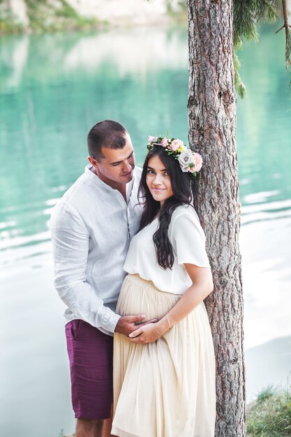 Femme enceinte avec son mari sur le lac