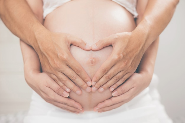 Femme enceinte et son mari main épissure serrant le ventre