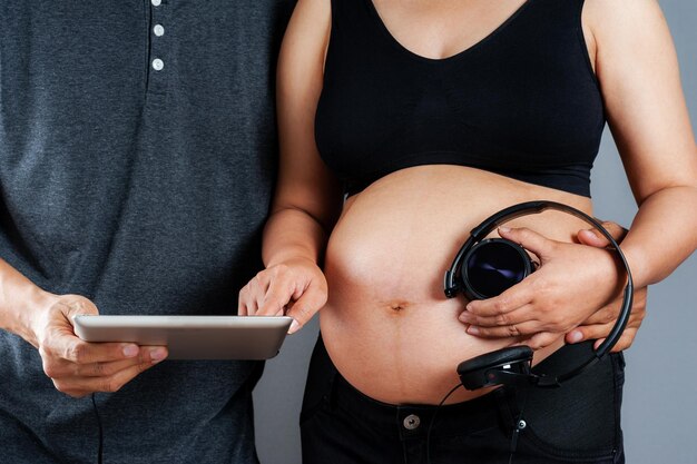 Femme enceinte et son mari sélectionnant les chansons pour bébé