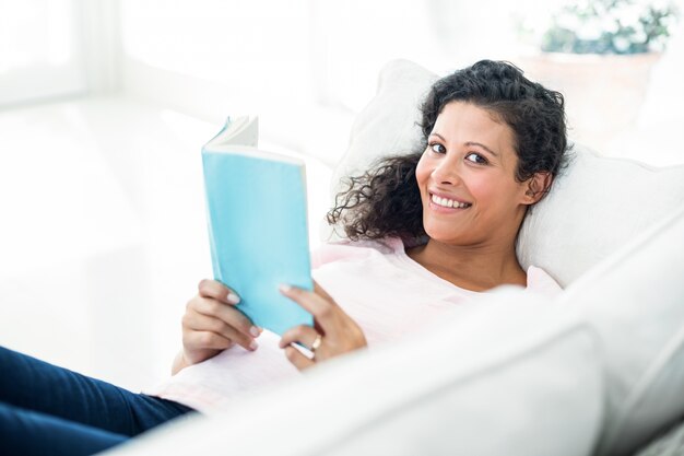 Femme enceinte en souriant en lisant un livre