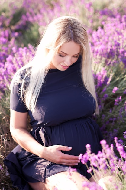 Femme enceinte souriante dans la prairie de fleurs de lavande