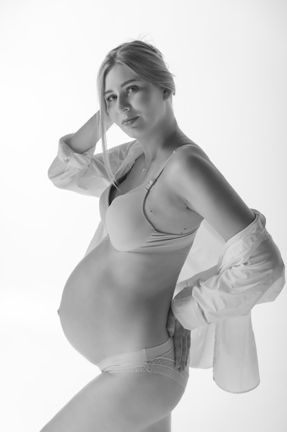 Femme enceinte en sous-vêtements sur fond blanc