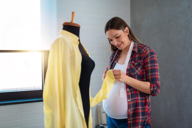 Photo femme enceinte tailleur ou couturière prenant des mesures de mannequin pour un motif de tissu avec mesure