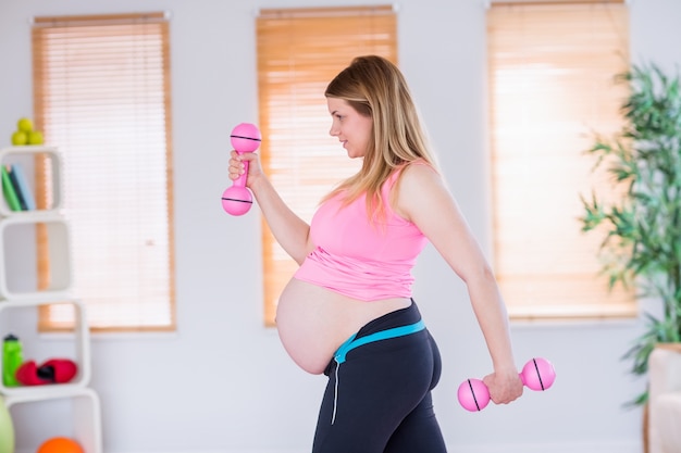 Une femme enceinte tenant des haltères