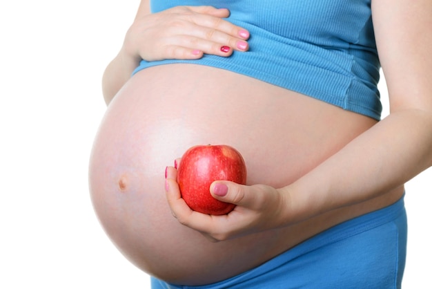 Femme enceinte tenant une pomme rouge