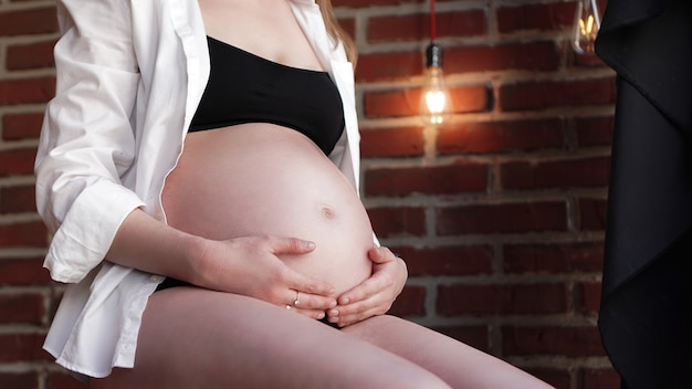 Femme enceinte tenant ses mains sur son baby bump