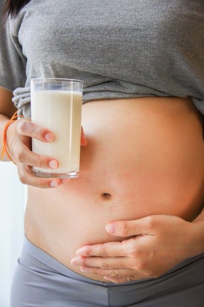 Femme enceinte tenant son ventre et lait biologique