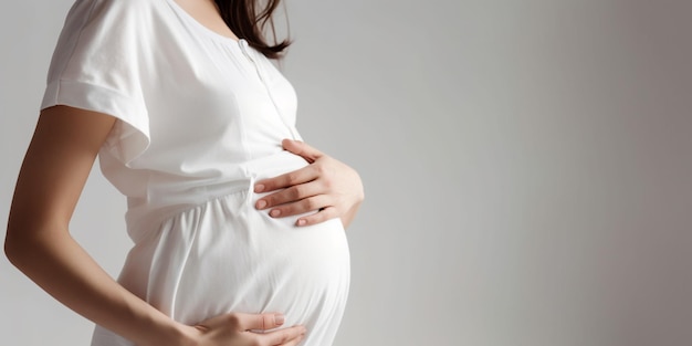 Femme enceinte touchant son ventre gros plan sur fond blanc